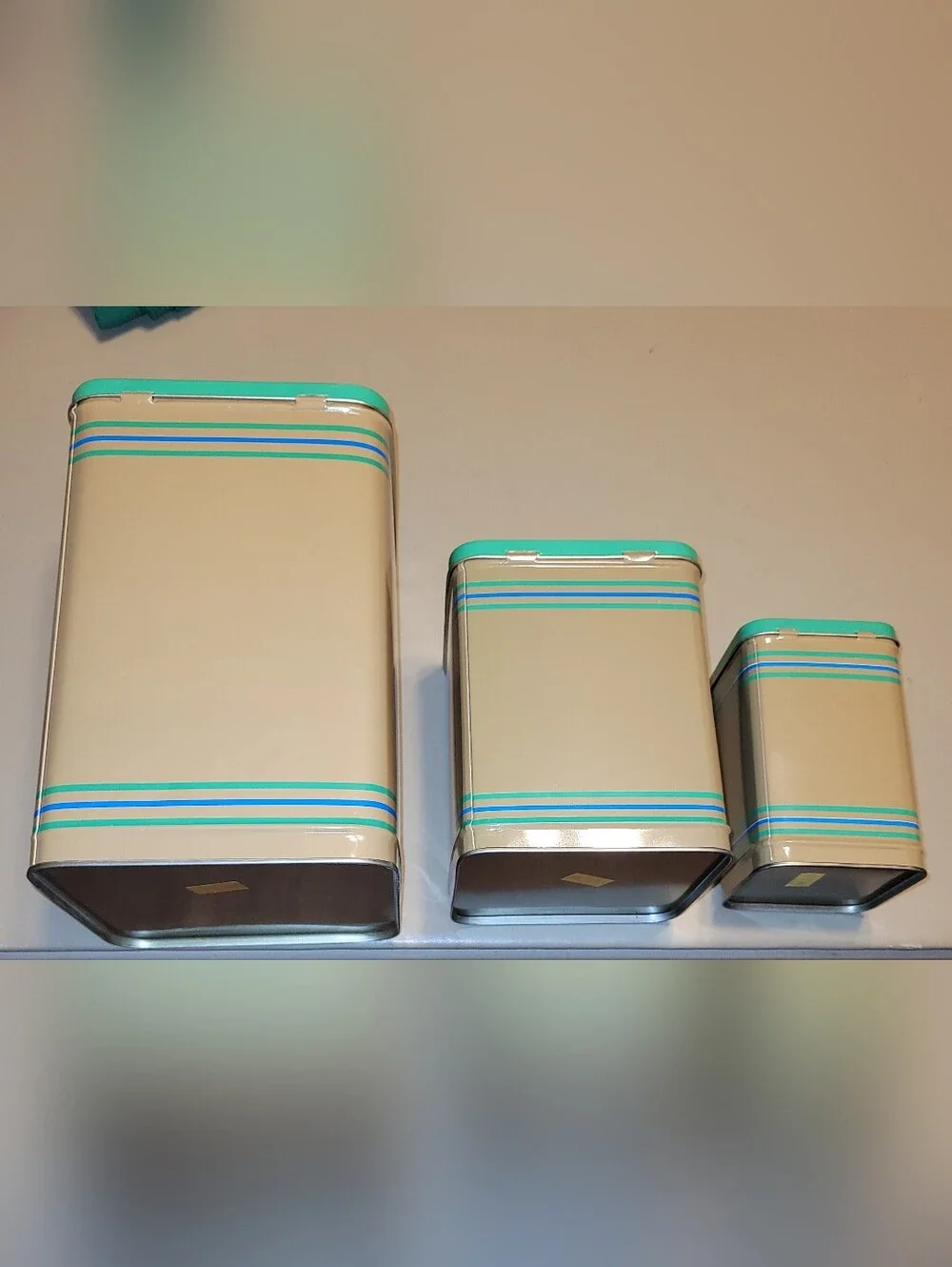 LASLO - Set of 3 Nesting Tan Metal Canisters with Green Lids and Stripes.
